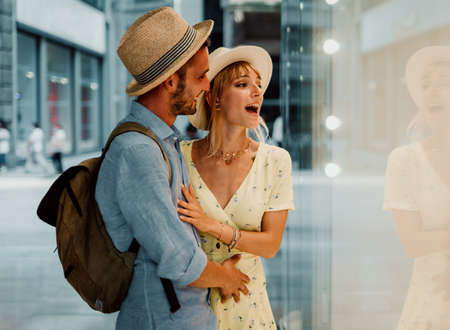 Side view of a beautiful couple doing some window shopping walking in the city.の写真素材