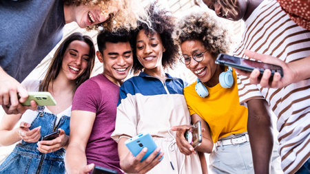 Group of multiracial young people using smart mobile phone device outdoorsの写真素材
