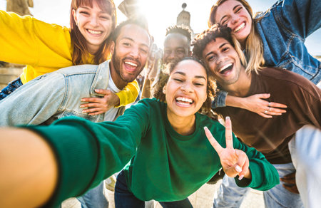 Multicultural friends taking selfie picture with smart mobile phone device outside