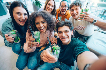 Multiracial friends drinking mojito cocktails at bar restaurantの写真素材