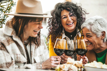 Happy senior women drinking red wine at bar restaurantの写真素材
