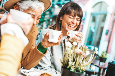 Three senior women enjoying breakfast drinking coffee at bar cafeteriaの写真素材
