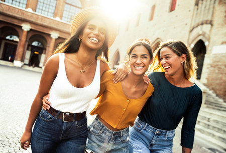 Three young diverse women having fun on city street outdoorsの写真素材