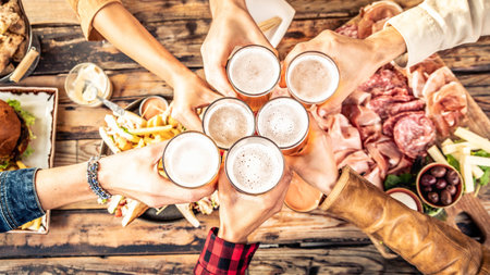Festive friends enjoying happy hour drinking beer at brewery pub bar restaurantの写真素材