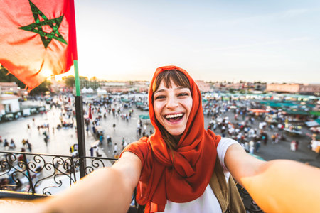 Happy tourist visiting Jamaa el-Fna market, Morocco - Beautiful female taking selfie enjoying summer vacation outsideの写真素材