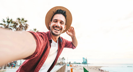 Happy young man taking selfie with smart mobile phone outdoors - Cheerful tourist having fun on...
