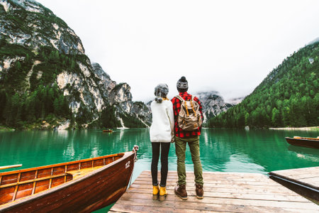 Couple visiting italian alpine Braies Lake - People enjoying stunning view of Lago di Braies in Dolomitesの写真素材
