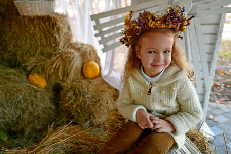 Little girl on a walk in the autumn city park.の写真素材