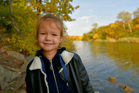 Little girl on a walk in the autumn forest.