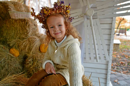 Little girl on a walk in the autumn city park.の写真素材