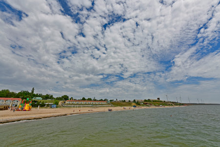 Ukraine, Primorsk 06/20/2020. Azov sea beach in Dorozhnik resort. Bungalows, sun loungers, vacationers and swimmers.のeditorial素材