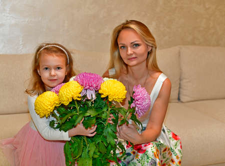 Mom and daughter with beautiful bouquets of flowers.の写真素材