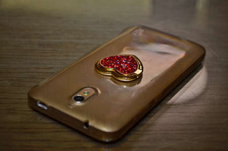 Smartphone in a transparent case with a heart.