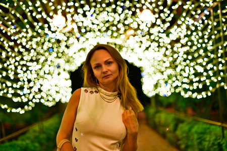 A woman in a restaurant is waiting for an order and looks into a smartphone.の写真素材