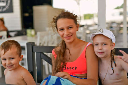 Children girls and boy play on the black sea shore in the sand.の写真素材