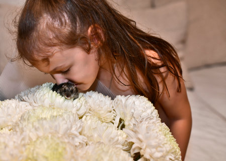 Beautiful woman and girl daughter with a big bouquet of flowers and a hamster on the flowers.の写真素材