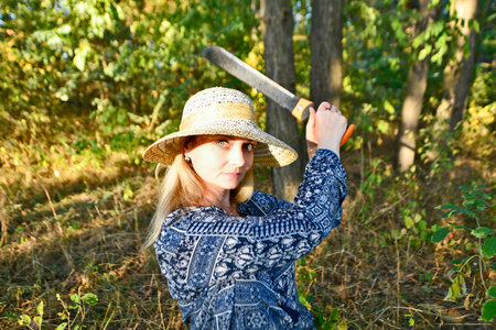 Beautiful sexy woman with a machete in the forest.