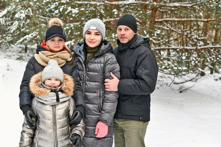 Two families walk in a winter snowy forest.の写真素材