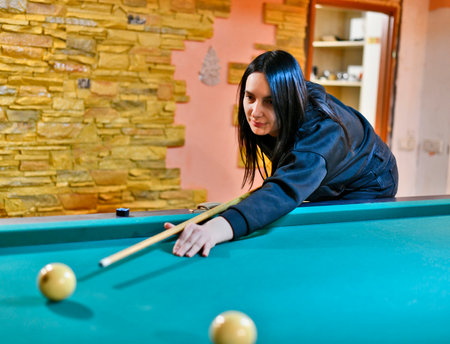 Adult men and women playing Russian billiards in a country house. Eastern Ukraine.