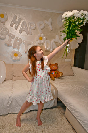 The family celebrates the child's birthday with friends. They have fun, entertain themselves, play games, eat a birthday cake.の写真素材