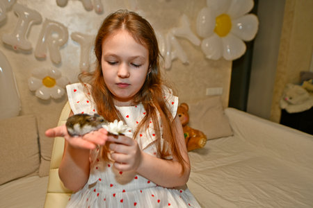 The family celebrates the child's birthday with friends. They have fun, entertain themselves, play games, eat a birthday cake.の写真素材