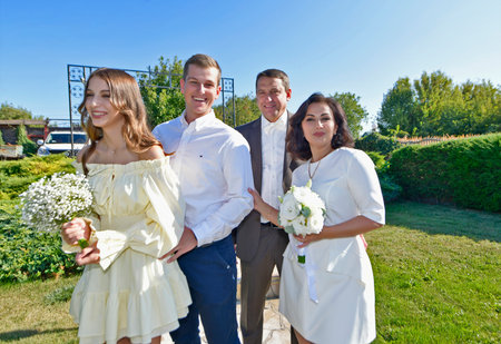 A mature couple, husband and wife, are celebrating their wedding anniversary with their children. A country recreation center on the shore of a lake, in September.の写真素材