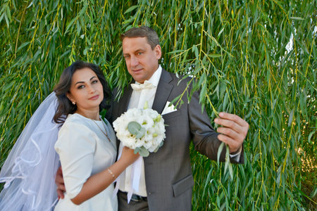 A mature couple, husband and wife, are celebrating their wedding anniversary with their children. A country recreation center on the shore of a lake, in September.の写真素材