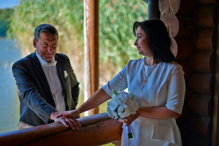 A mature couple, husband and wife, are celebrating their wedding anniversary with their children. A country recreation center on the shore of a lake, in September.の写真素材