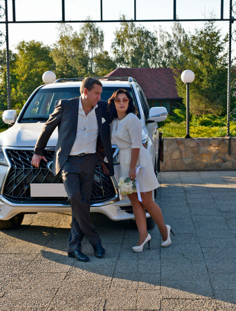 A mature couple, husband and wife, are celebrating their wedding anniversary with their children. A country recreation center on the shore of a lake, in September.の写真素材
