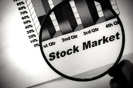 black stock market chart under a magnifying glassの写真素材