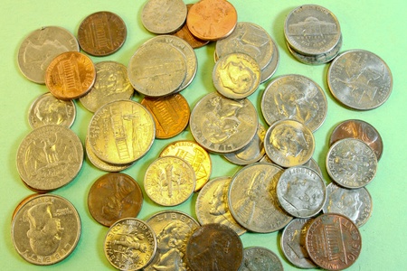 American coins scattered about  on green paper