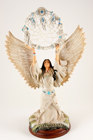 Pretty Native American woman in dress holding dreamcatcher with feathers above her head isolated on white backgroundの写真素材