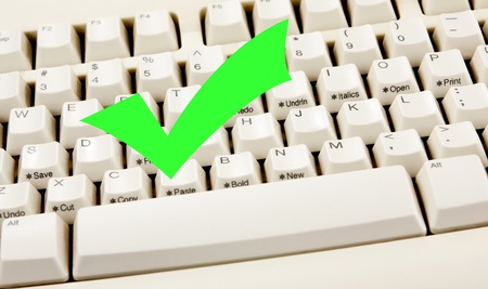 Green check mark on white keyboardの写真素材