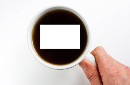 White blank card in coffee with hand on coffee cup over white