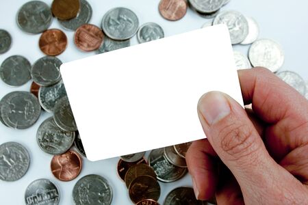 Blank white card over coins with handの写真素材