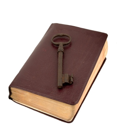 Antique rusty key sitting on top of an old leather bookの写真素材