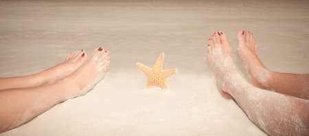 Sandy feet with a starfish at the beachの写真素材