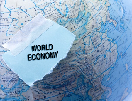 World economy written on  blue torn paper on top of a globeの写真素材