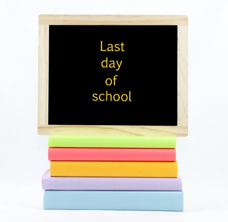 Last day of school text on a chalkboard on top of colored books