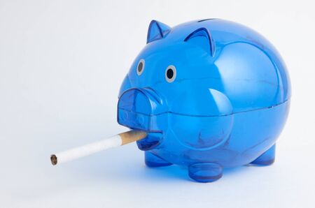 A blue piggy bank smoking a cigaretteの写真素材