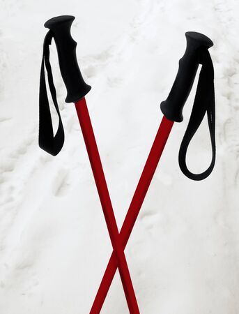 Crossed red ski poles in the snowの写真素材