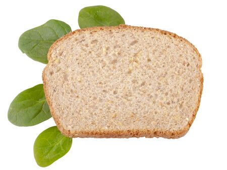A slice of whole wheat bread with three spinach leaves isolated on whiteの写真素材