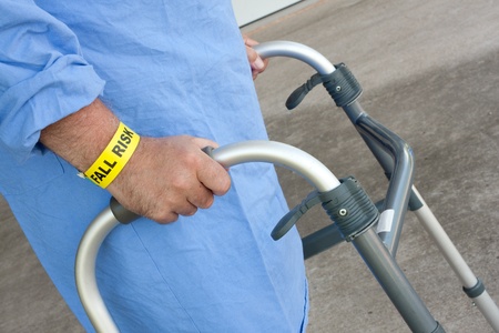 A hospital patient wearing a fall risk bracelet using a walkerの写真素材