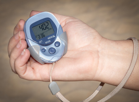 A woman holding a pedometer in hand