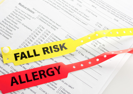 Fall Risk And Allergy Bracelet on top of a hospital questionnaireの写真素材
