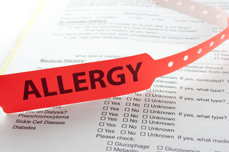 An allergy patient bracelet on top of a hospital questionnaire paperworkの写真素材