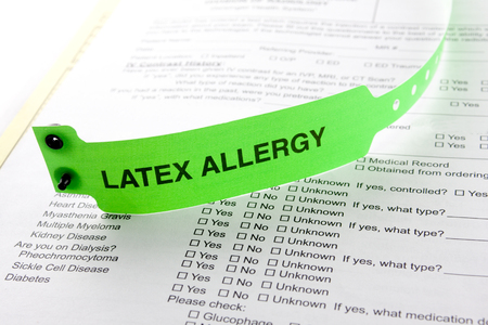 A latex allergy patient bracelet on top of a hospital questionnaire paperworkの写真素材