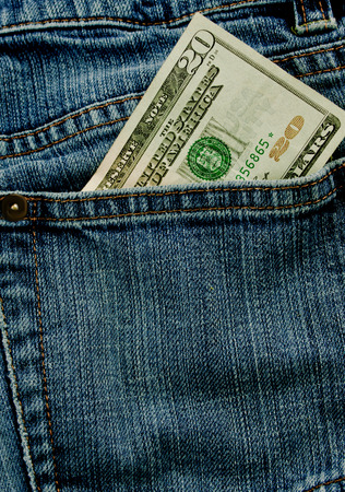A twenty dollar bill sticking out the back pocket of denim blue jeansの写真素材