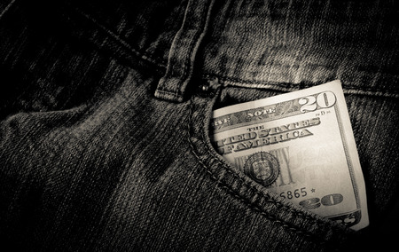 Cash in a front pocket of a pair of black jeansの写真素材