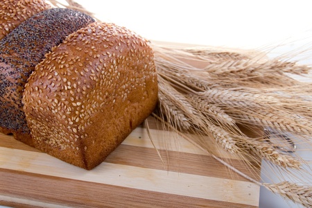 Fresh bread with ears of wheat  on a white background